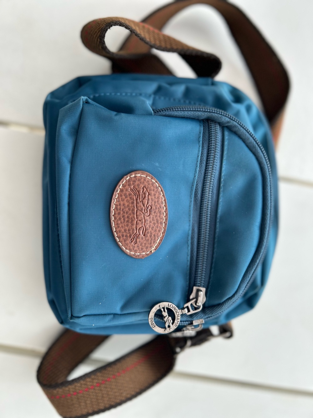 vintage Blue nylon Longchamp crossbody bag featuring a brown leather oval logo